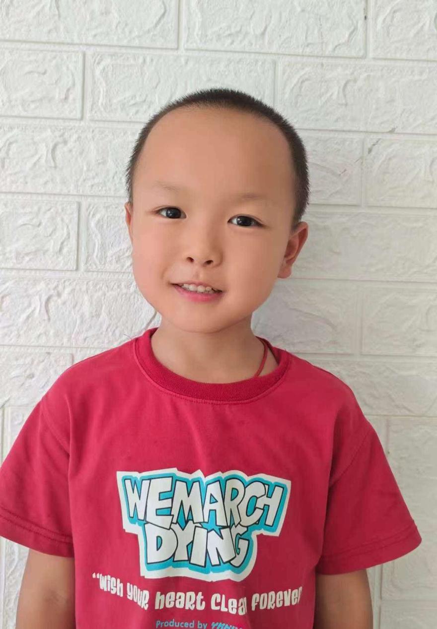 孩子在白墙前站得笔直，神情拘谨